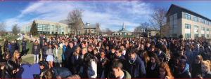 STUDENTS GATHER AT FLAGPOLE: during the nationwide walkout EA students sign a card to be sent to the victims of the Parkland shooting. Photo courtesy of Parisa Afsharian '19